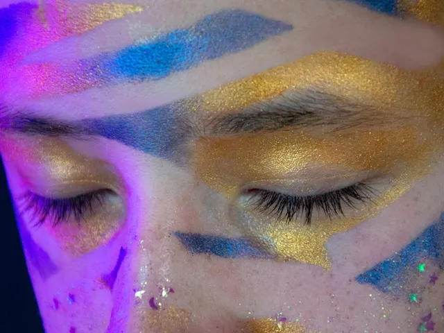 Closeup of artistic festival makeup with vibrant colors on closed eyes.